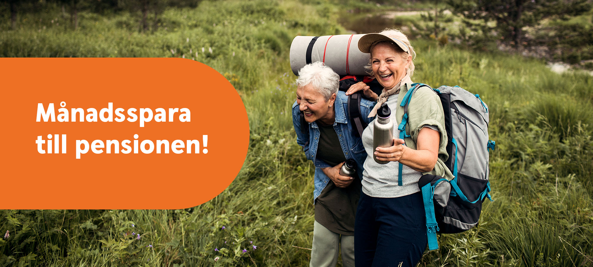 Två äldre kvinnor med vandringsutrustning skrattar tillsammans